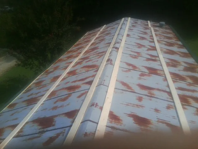 Rusted metal roof panels with new wood purlins before replacement — Storm Damage Roof Repair in Adair by Roofing Brothers